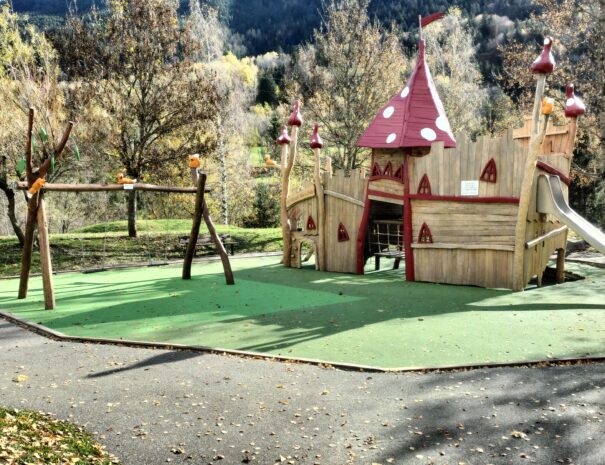 Aire de jeux pour jeunes enfants à Bozel, avec toboggans et structures ludiques entourées de verdure.